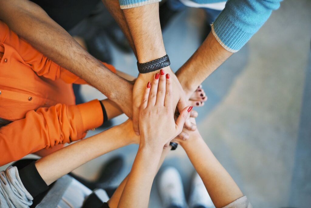 A group of people holding hands in the middle of a circle.