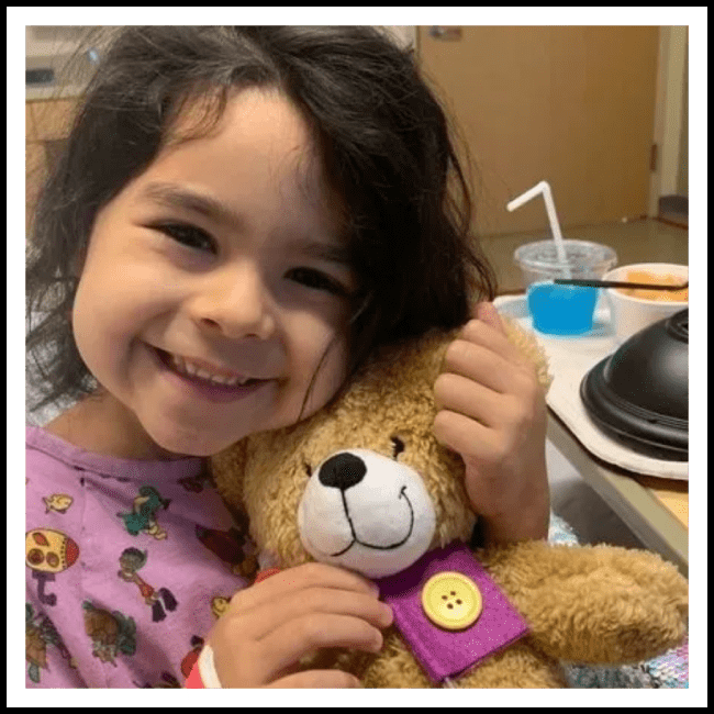 A little girl holding onto a teddy bear