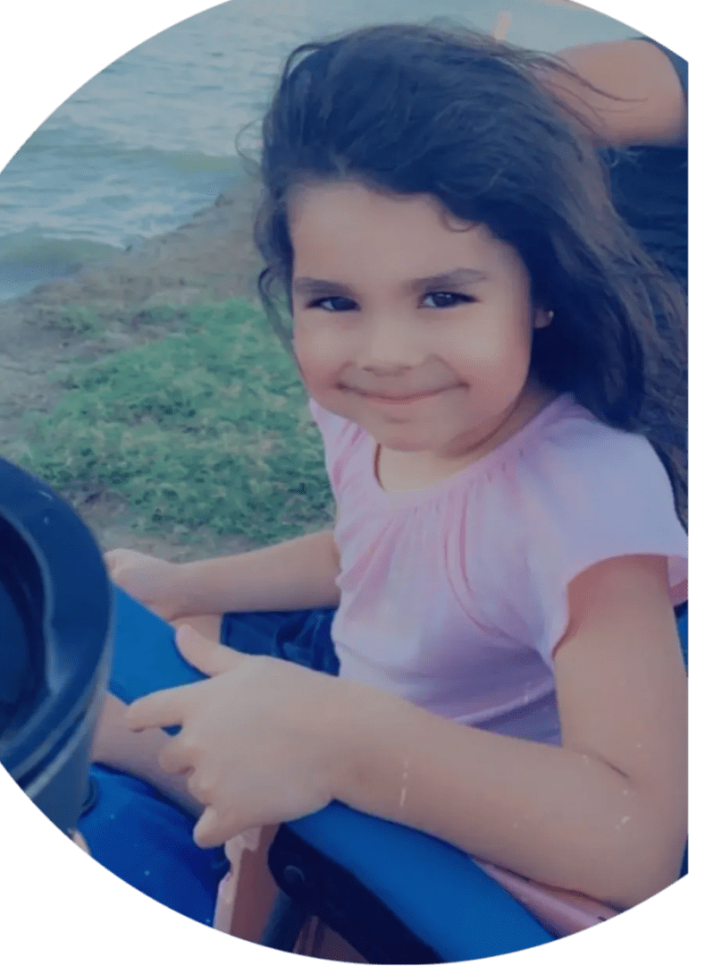 A young girl sitting on top of a blue and green chair.